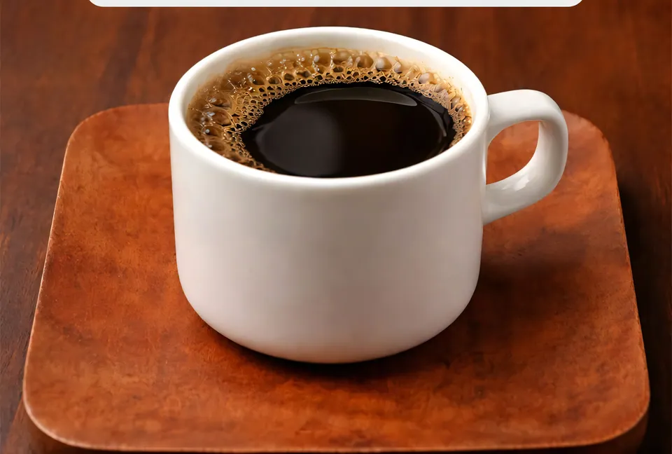 A cup of black coffee on a wooden coaster